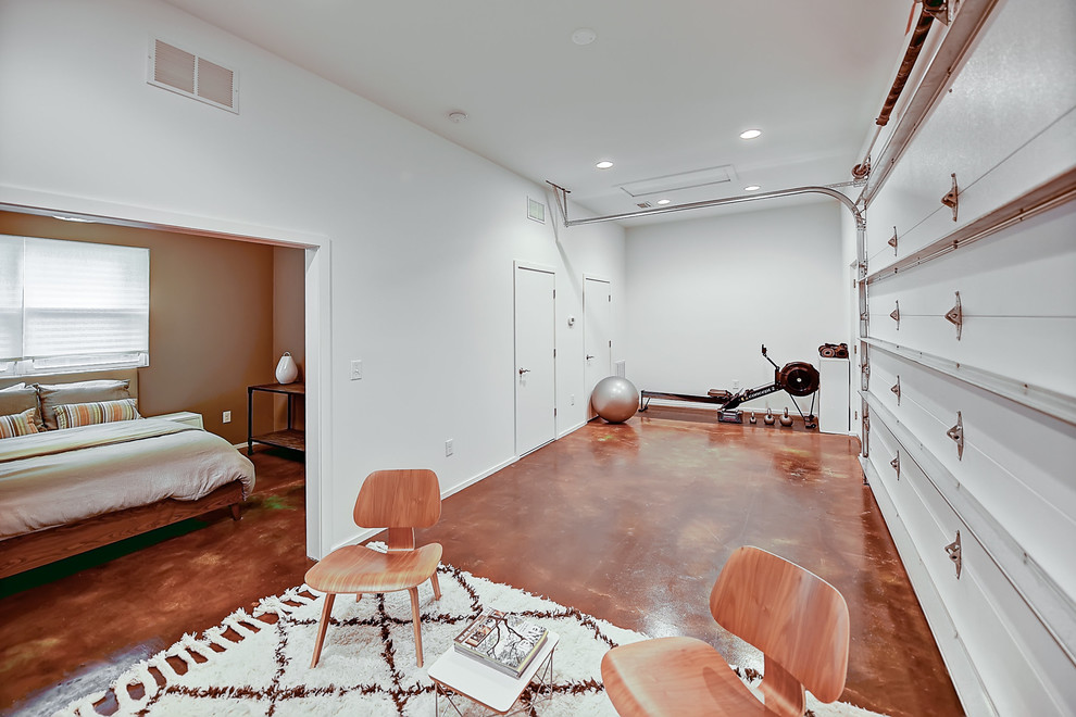 Modelo de sala de juegos en casa abierta minimalista con paredes blancas y suelo de cemento