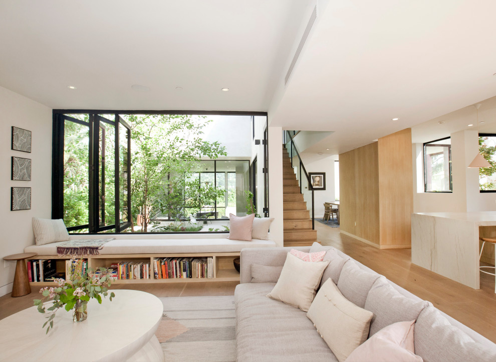 Mittelgroßes, Offenes Modernes Wohnzimmer mit weißer Wandfarbe, hellem Holzboden, TV-Wand und braunem Boden in Los Angeles
