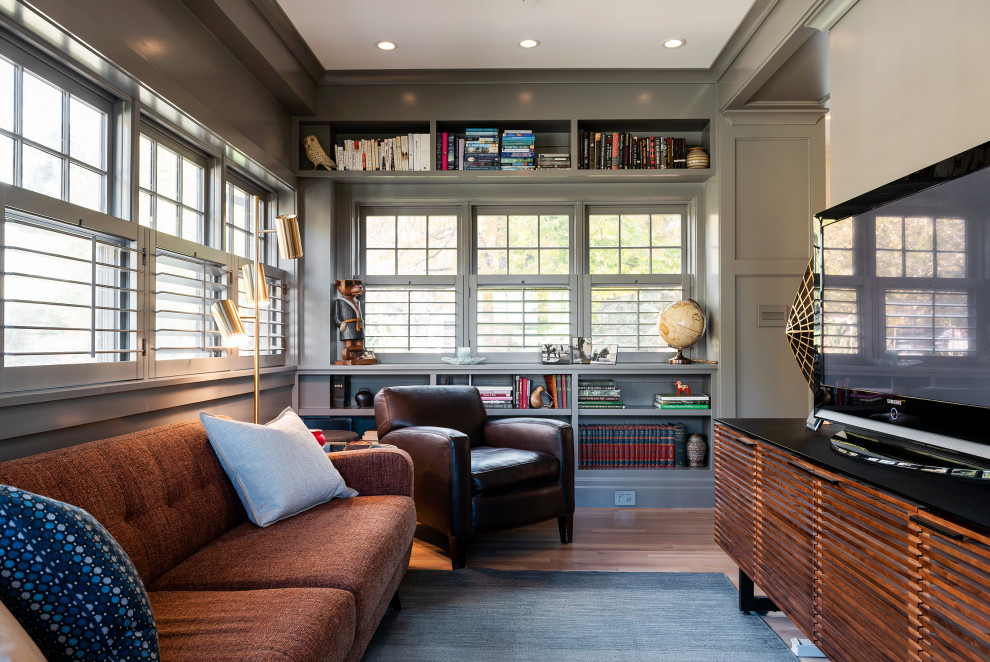 Diseño de sala de estar tradicional con paredes grises, suelo de madera en tonos medios, televisor independiente y suelo marrón