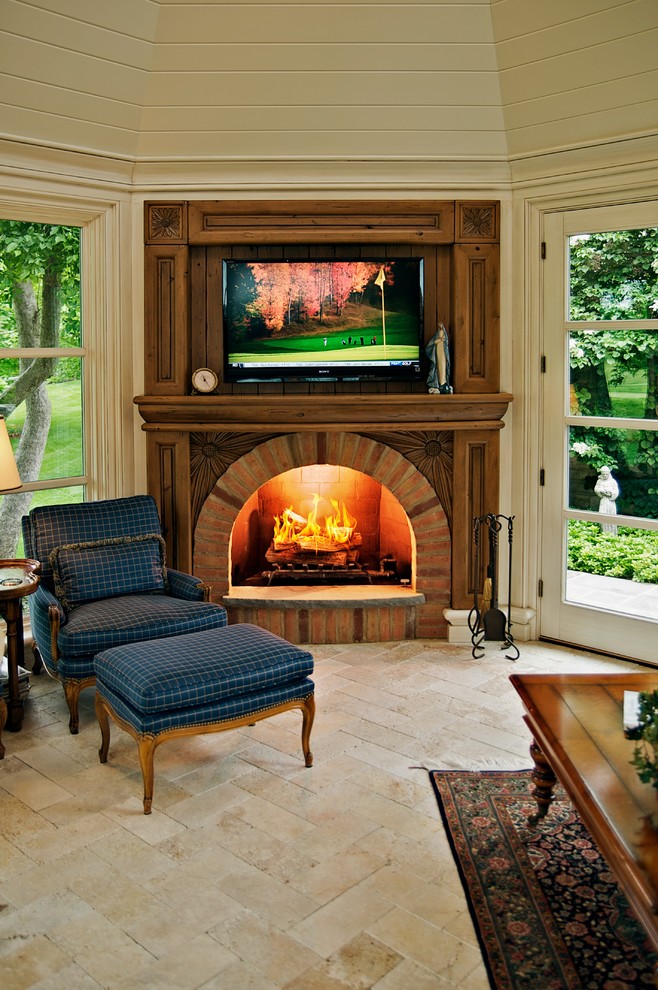 Réalisation d'une salle de séjour tradition avec un mur beige, une cheminée standard, un manteau de cheminée en brique et un téléviseur fixé au mur.