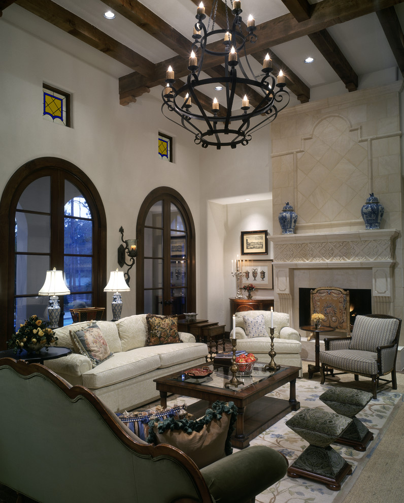 Imagen de sala de estar abierta bohemia grande con paredes blancas, todas las chimeneas y marco de chimenea de piedra