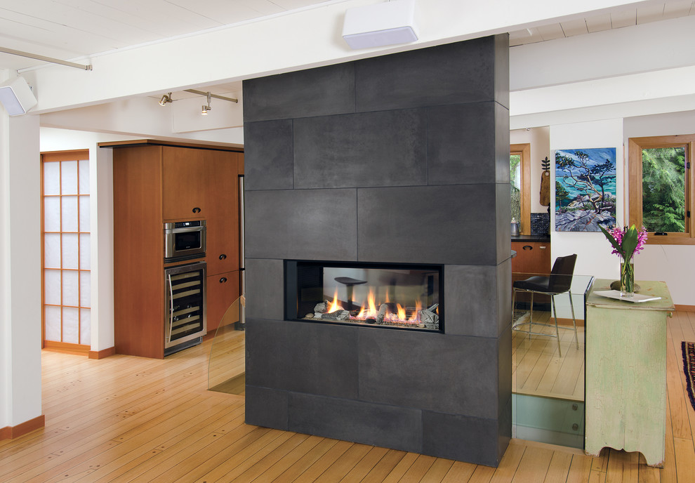 サンフランシスコにある広いコンテンポラリースタイルのおしゃれなオープンリビング (両方向型暖炉、タイルの暖炉まわり、白い壁、淡色無垢フローリング、テレビなし) の写真