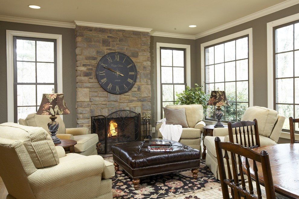 Пример оригинального дизайна: гостиная комната в классическом стиле с коричневыми стенами, стандартным камином и фасадом камина из камня