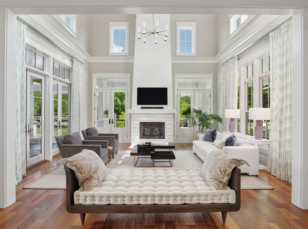 Großes, Offenes Modernes Wohnzimmer mit grauer Wandfarbe, dunklem Holzboden, Kamin, Kaminumrandung aus Holzdielen, TV-Wand, braunem Boden und gewölbter Decke in Charleston