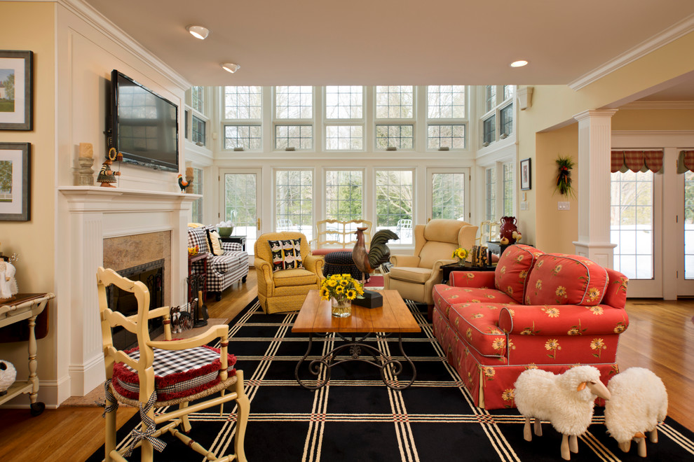 Стильный дизайн: большая открытая гостиная комната в стиле кантри с желтыми стенами, светлым паркетным полом, стандартным камином, фасадом камина из дерева и телевизором на стене - последний тренд