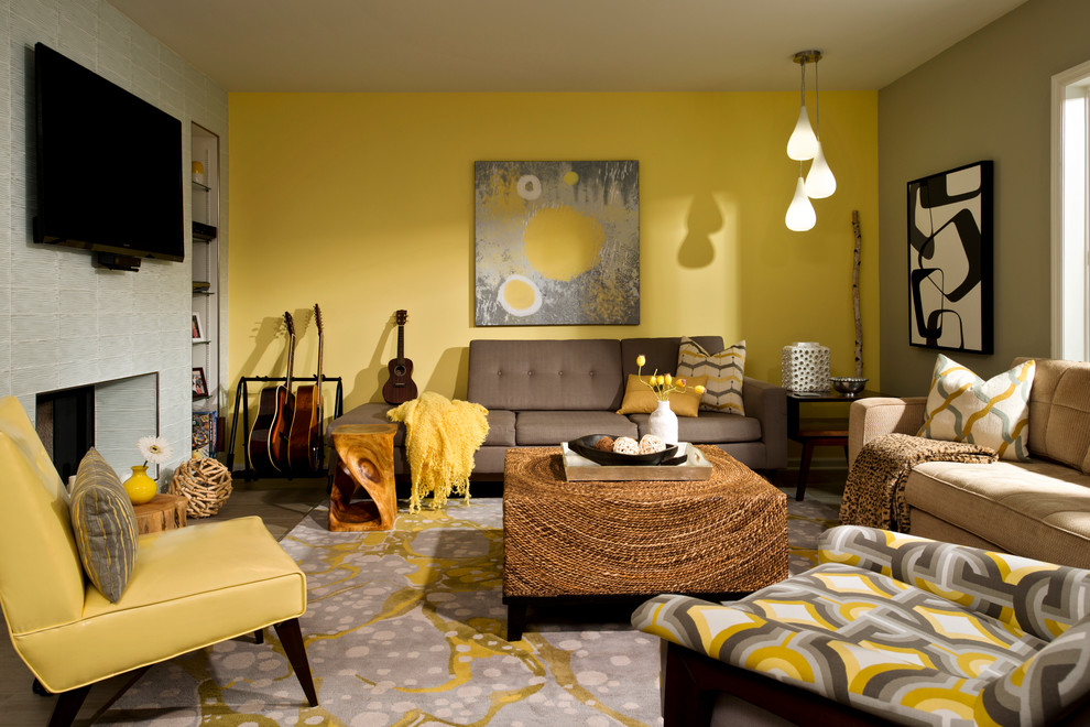 Modelo de sala de estar cerrada vintage de tamaño medio con paredes amarillas, suelo de baldosas de porcelana, chimenea de doble cara, marco de chimenea de baldosas y/o azulejos y televisor colgado en la pared