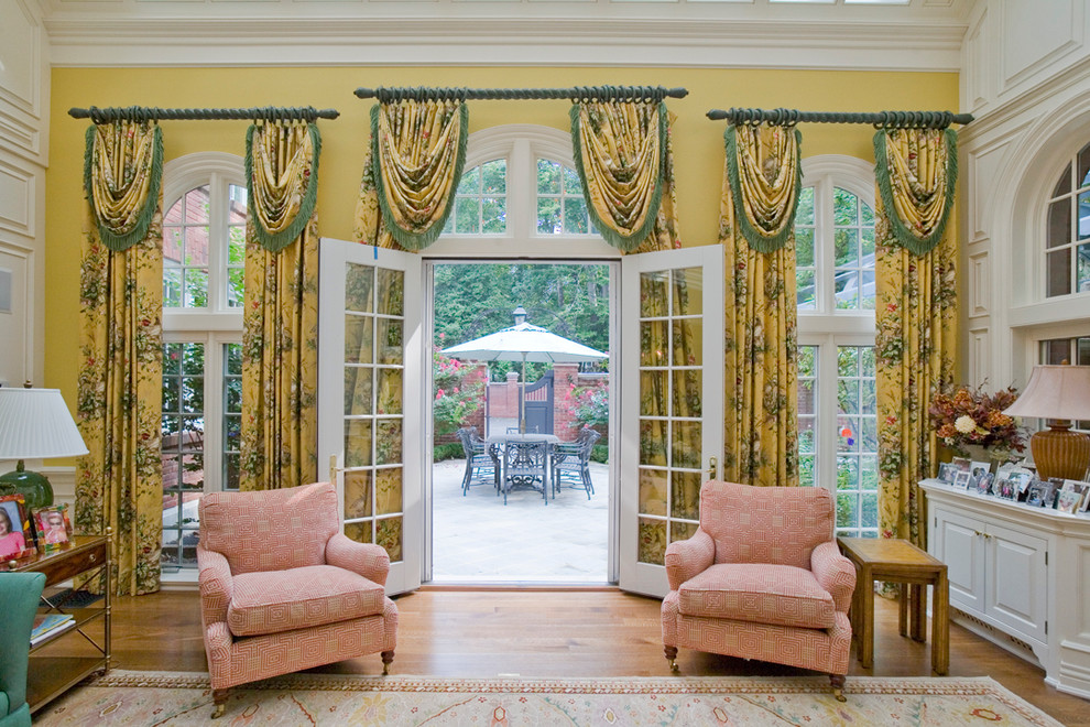 Пример оригинального дизайна: гостиная комната в классическом стиле с желтыми стенами и паркетным полом среднего тона