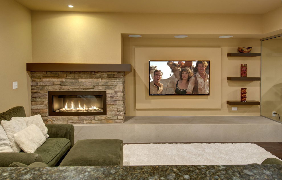Foto de sala de estar con barra de bar abierta tradicional renovada de tamaño medio con paredes beige, suelo de madera oscura, chimenea lineal, marco de chimenea de piedra, televisor colgado en la pared y suelo marrón