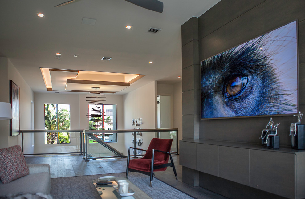 Inspiration for a medium sized contemporary mezzanine games room in Miami with brown walls, light hardwood flooring, a wall mounted tv and brown floors.