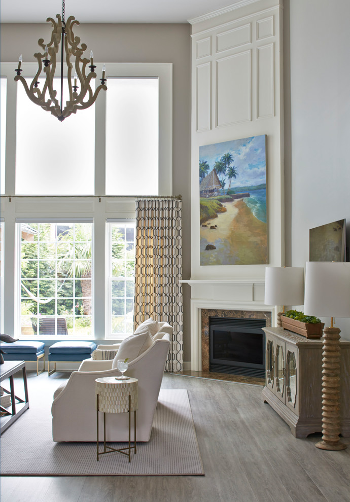На фото: большая открытая гостиная комната в стиле неоклассика (современная классика) с серыми стенами, полом из винила, угловым камином, фасадом камина из дерева, телевизором на стене и серым полом