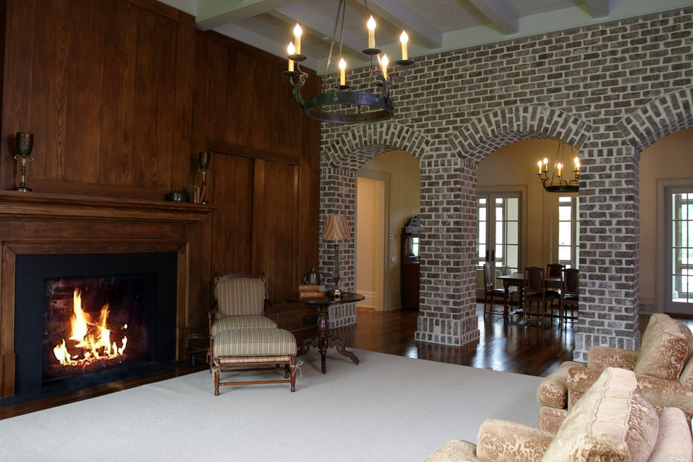 Example of a classic enclosed carpeted family room library design in Other with brown walls, a standard fireplace and a wood fireplace surround