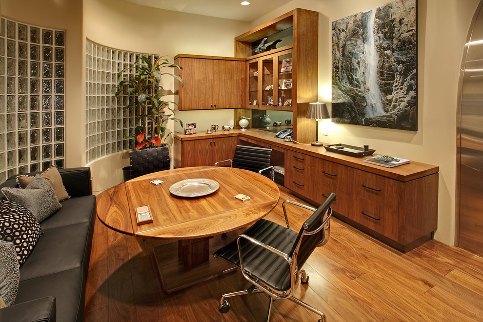 Example of a large island style enclosed dark wood floor game room design in Orange County with beige walls, no fireplace and no tv