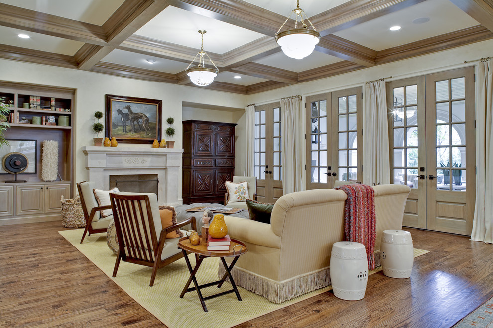 Diseño de sala de estar abierta tradicional con paredes beige, suelo de madera en tonos medios, todas las chimeneas y marco de chimenea de piedra