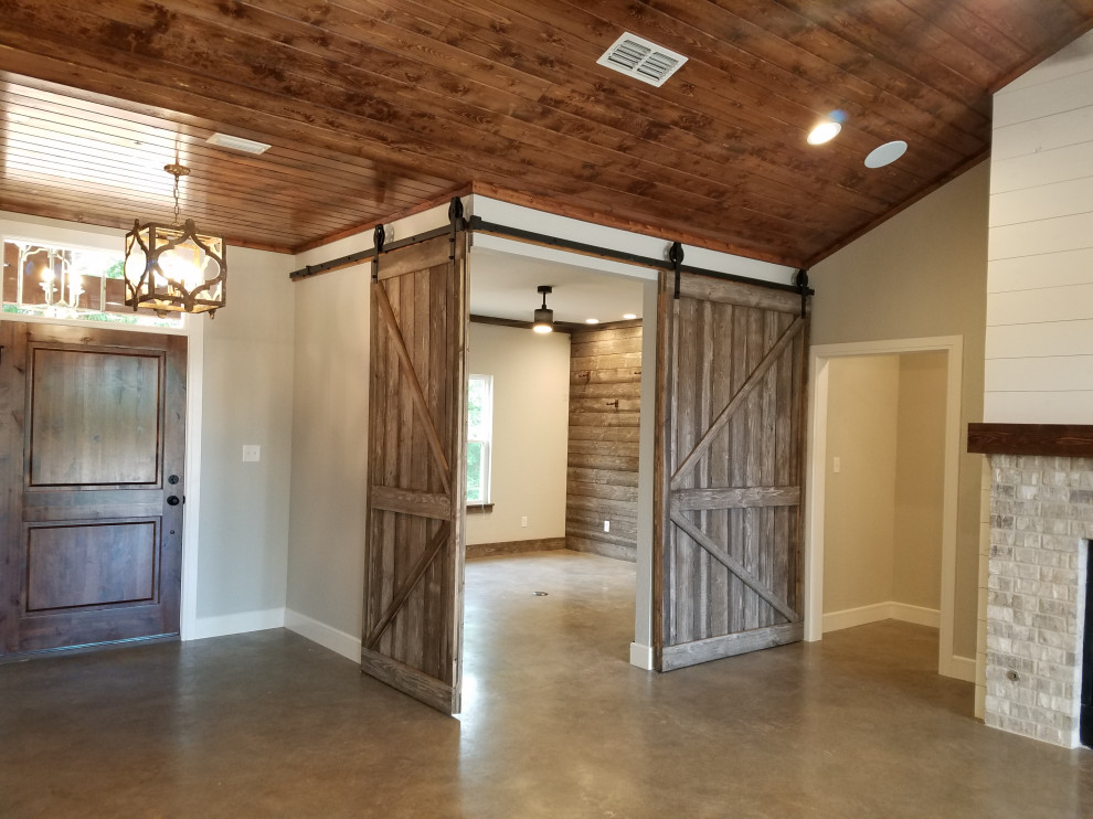 Rural open plan games room in Dallas with a music area, grey walls, concrete flooring, grey floors and wood walls.