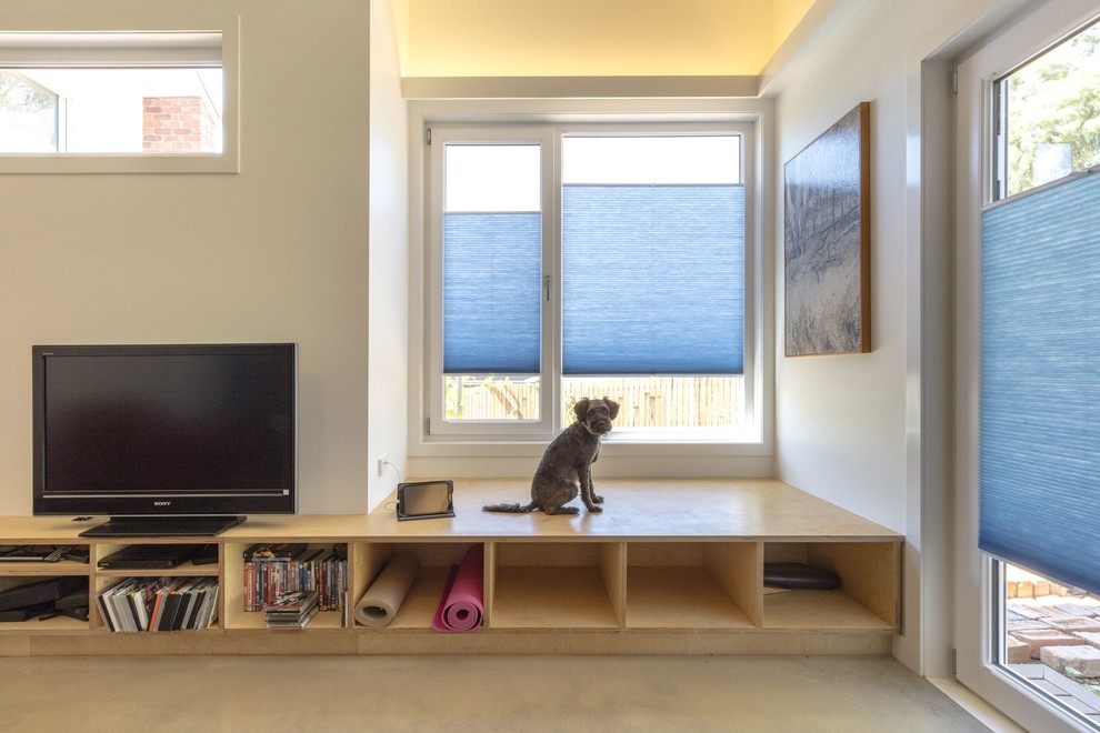 Exemple d'une salle de séjour tendance de taille moyenne et ouverte avec un mur blanc et un téléviseur encastré.