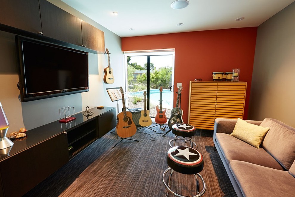 Идея дизайна: изолированная гостиная комната в стиле модернизм с музыкальной комнатой, оранжевыми стенами, ковровым покрытием и телевизором на стене