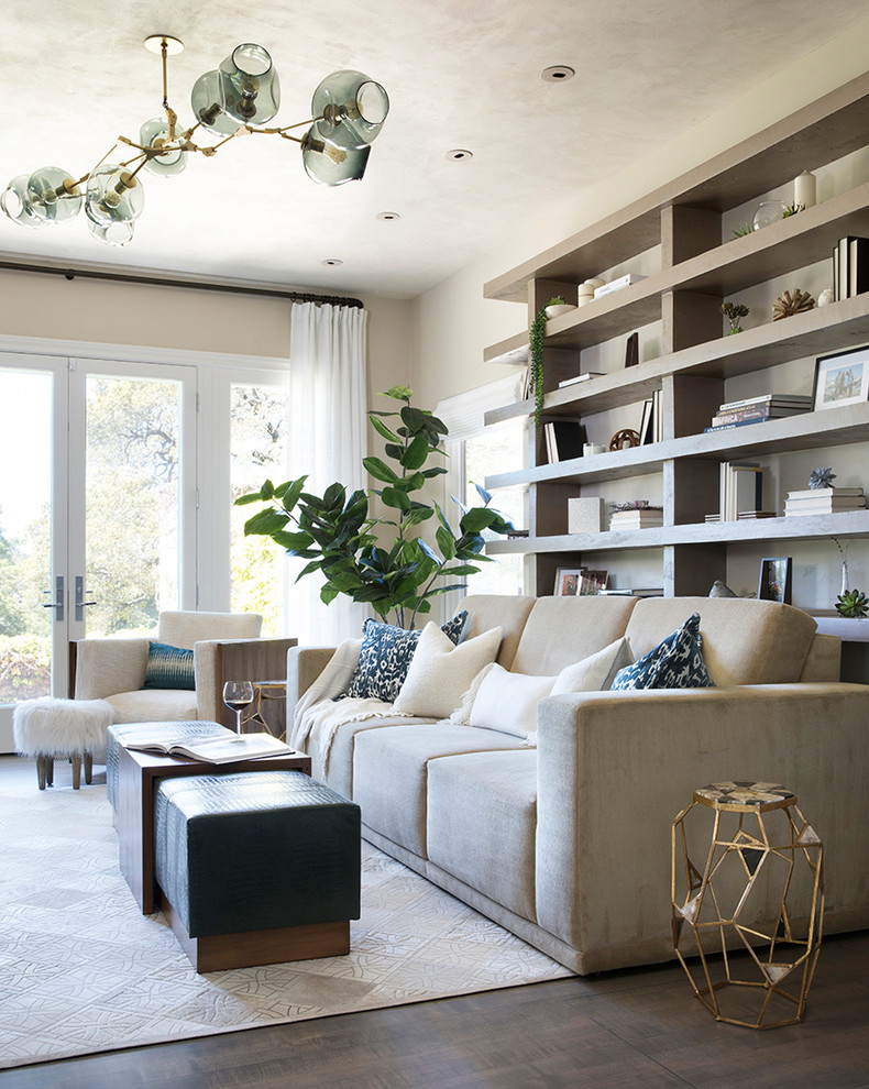Modelo de sala de estar con biblioteca cerrada contemporánea con paredes beige, suelo de madera oscura, chimenea de esquina, marco de chimenea de hormigón y suelo gris