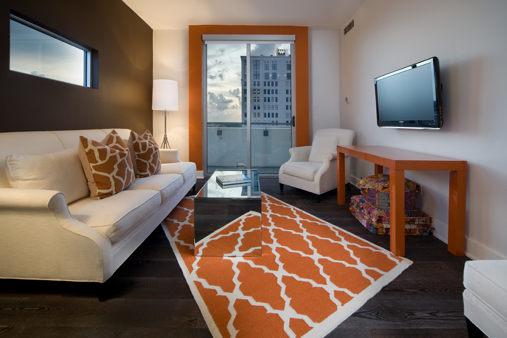 Cette image montre une salle de séjour design fermée avec un mur marron, parquet foncé et un téléviseur fixé au mur.