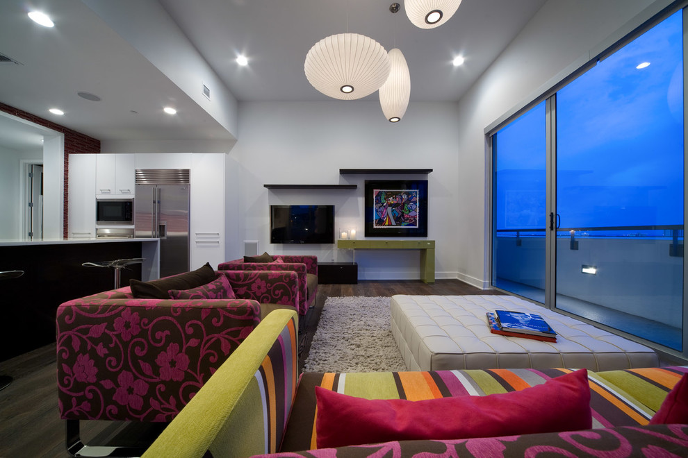 Offenes Modernes Wohnzimmer mit weißer Wandfarbe, dunklem Holzboden und TV-Wand in Tampa