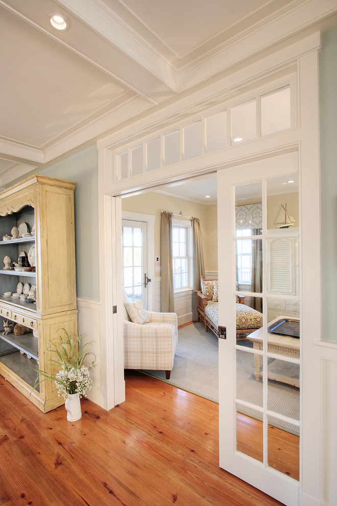 Diseño de sala de estar con biblioteca abierta costera de tamaño medio con paredes azules
