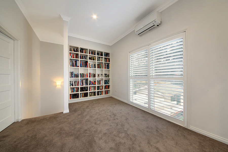 Exemple d'une salle de séjour tendance de taille moyenne et ouverte avec une bibliothèque ou un coin lecture, un mur blanc, moquette et aucun téléviseur.