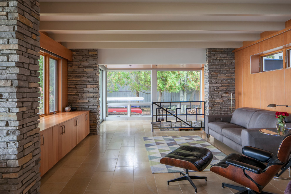 На фото: открытая гостиная комната среднего размера в стиле ретро с коричневыми стенами, полом из керамогранита и скрытым телевизором без камина с