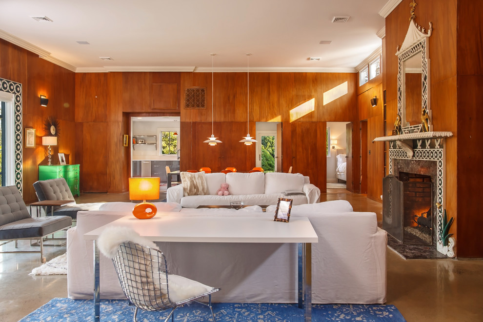 Источник вдохновения для домашнего уюта: большая открытая гостиная комната в стиле ретро с бетонным полом, стандартным камином, фасадом камина из камня и отдельно стоящим телевизором