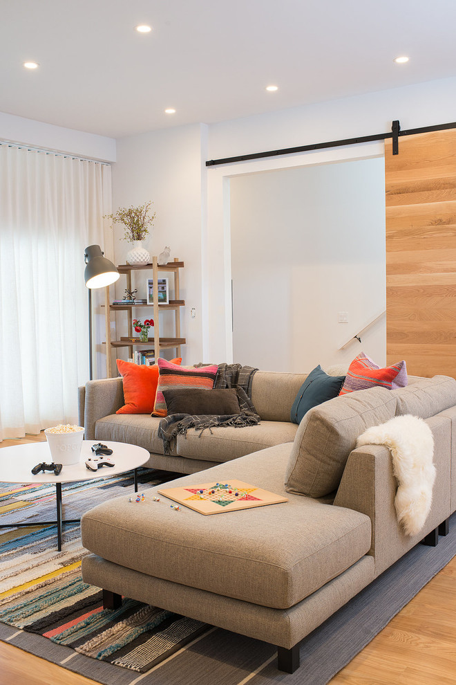 Immagine di un soggiorno minimal di medie dimensioni e aperto con pareti bianche, parquet chiaro, nessun camino, TV a parete e pavimento marrone