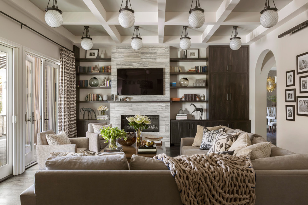 Example of a tuscan enclosed coffered ceiling living room library design in Los Angeles with beige walls, a ribbon fireplace, a stone fireplace and a wall-mounted tv