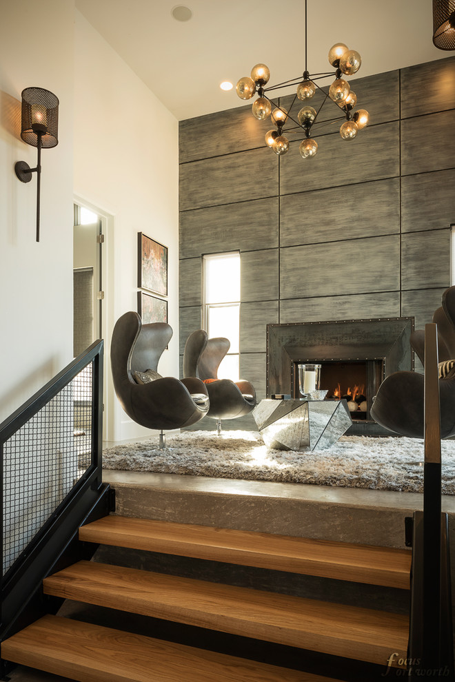 Immagine di un piccolo soggiorno minimalista stile loft con pareti beige, pavimento in cemento, camino classico, cornice del camino in metallo e nessuna TV