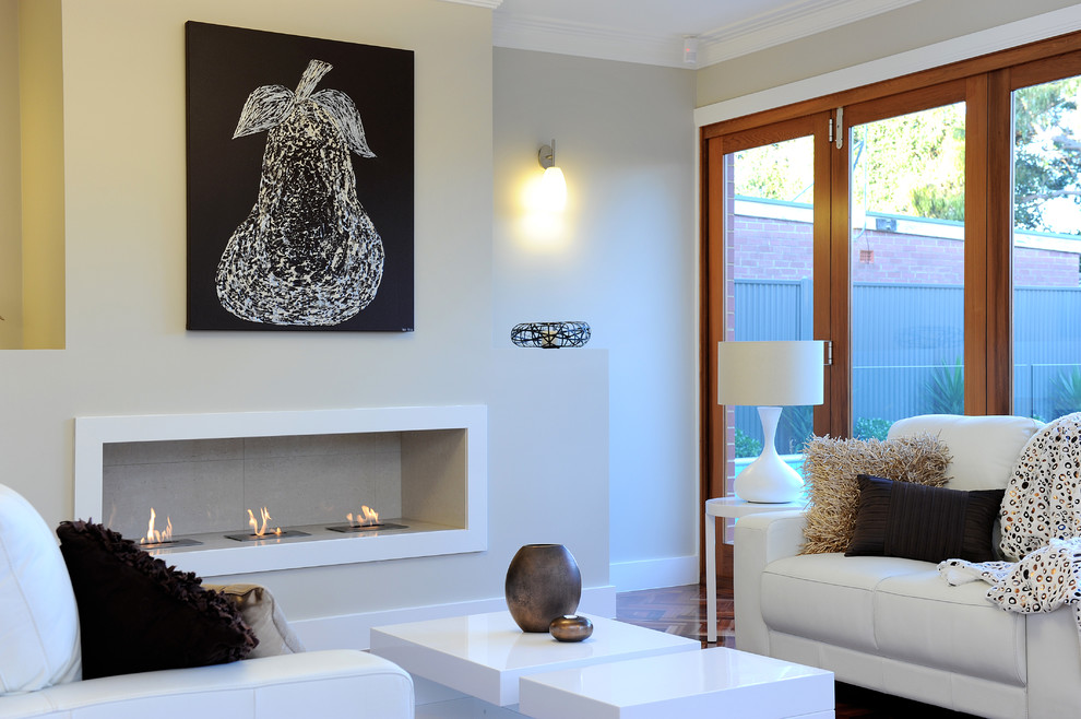 Foto di un grande soggiorno contemporaneo aperto con pareti beige, parquet scuro, camino classico, nessuna TV e cornice del camino in intonaco