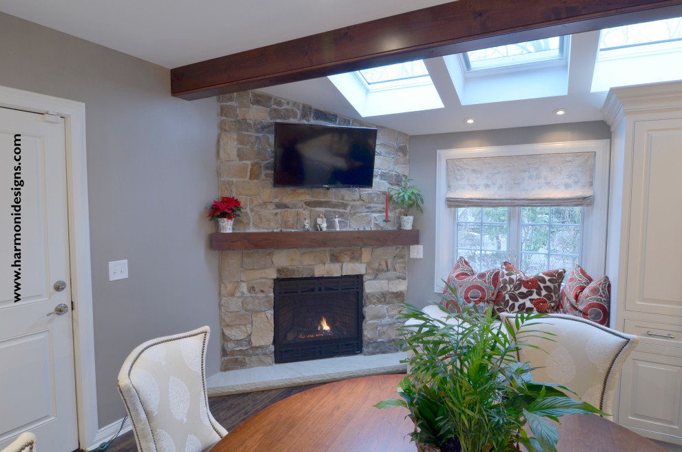 Classic games room with dark hardwood flooring, a corner fireplace, a stone fireplace surround and a wall mounted tv.