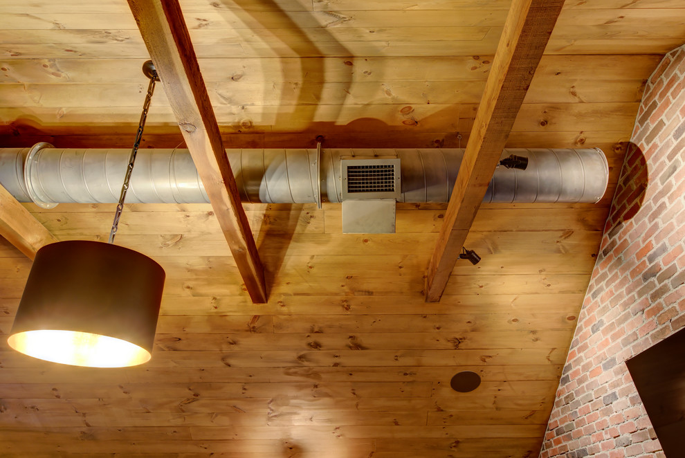 Idéer för ett mellanstort industriellt allrum på loftet, med en hemmabar, grå väggar, mörkt trägolv, en väggmonterad TV och brunt golv