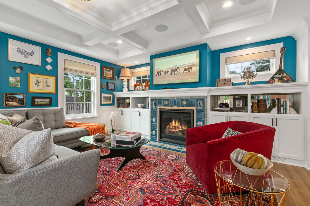 Mid-sized eclectic medium tone wood floor family room library photo in Minneapolis with blue walls, a standard fireplace, a tile fireplace and a wall-mounted tv