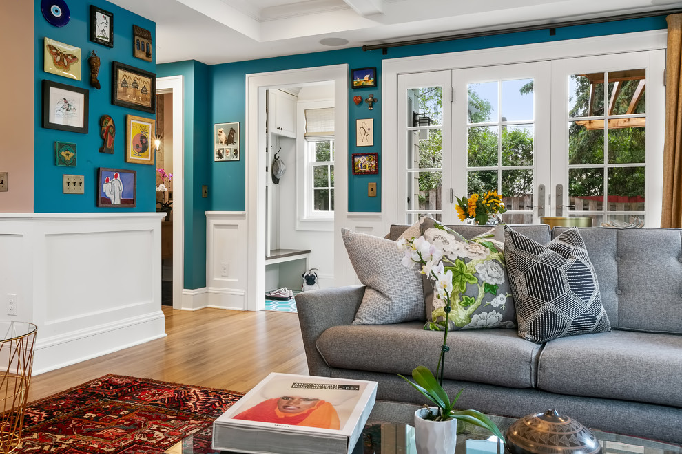 Idées déco pour une salle de séjour éclectique de taille moyenne et ouverte avec un mur bleu, parquet clair, une cheminée standard, un manteau de cheminée en carrelage, un téléviseur fixé au mur et un sol jaune.