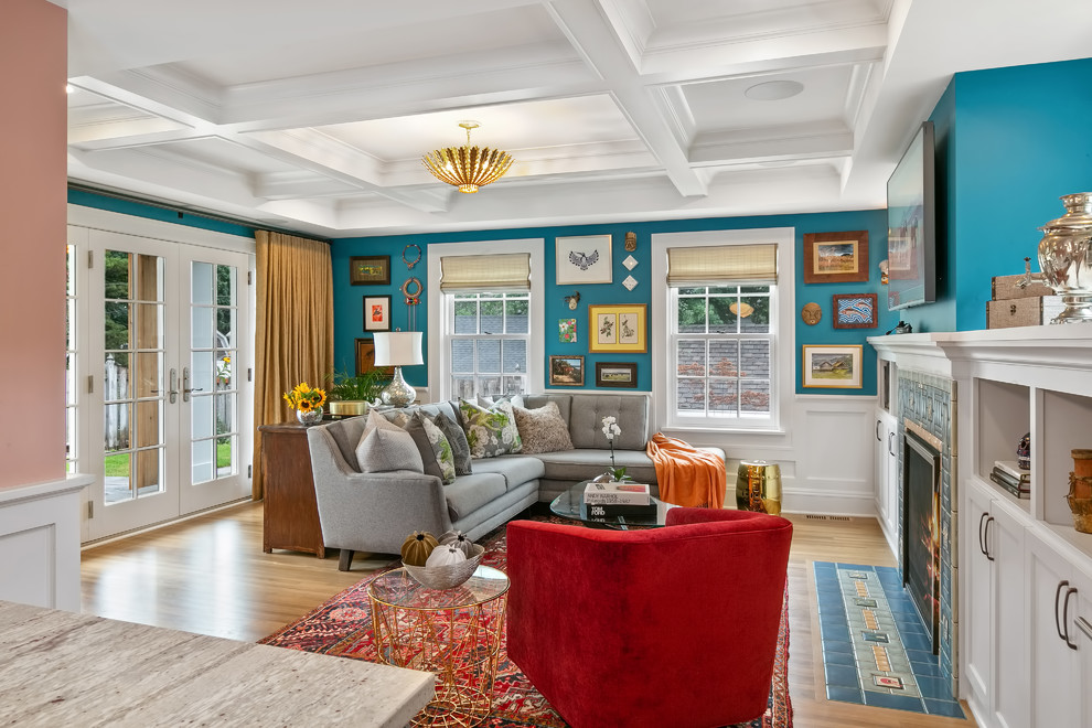 Aménagement d'une salle de séjour éclectique de taille moyenne et ouverte avec un mur bleu, parquet clair, une cheminée standard, un manteau de cheminée en carrelage, un téléviseur fixé au mur et un sol jaune.