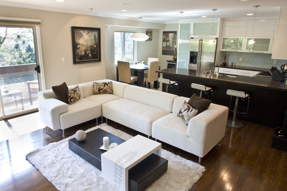 Foto de sala de estar abierta contemporánea con paredes beige, suelo de madera oscura y alfombra