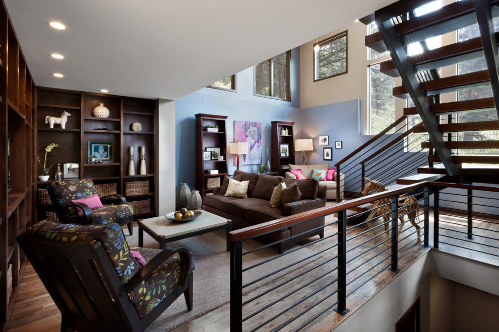 Идея дизайна: двухуровневая гостиная комната в современном стиле с серыми стенами, паркетным полом среднего тона и коричневым диваном