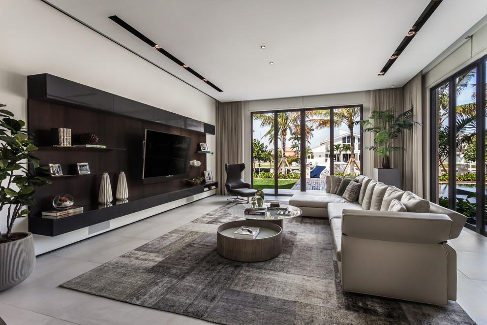 Großes, Offenes Modernes Wohnzimmer ohne Kamin mit weißer Wandfarbe, Porzellan-Bodenfliesen, Multimediawand und grauem Boden in Miami