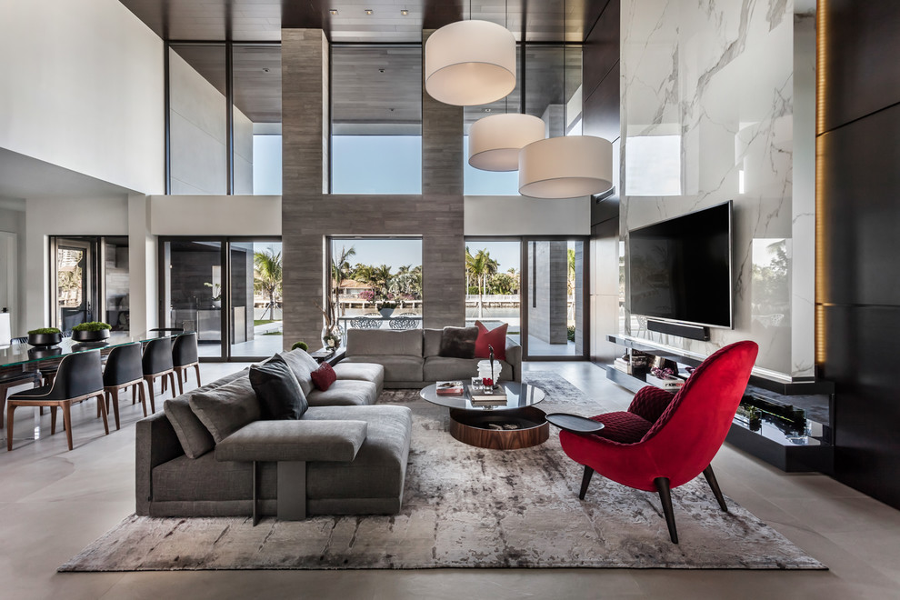 Geräumiges, Offenes Modernes Wohnzimmer mit Porzellan-Bodenfliesen, TV-Wand, weißer Wandfarbe und grauem Boden in Miami