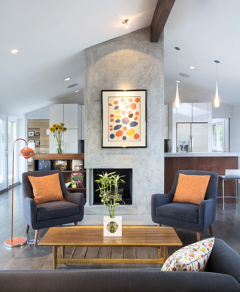 Cette image montre une salle de séjour design ouverte et de taille moyenne avec un manteau de cheminée en plâtre, une cheminée d'angle, un mur gris et parquet foncé.