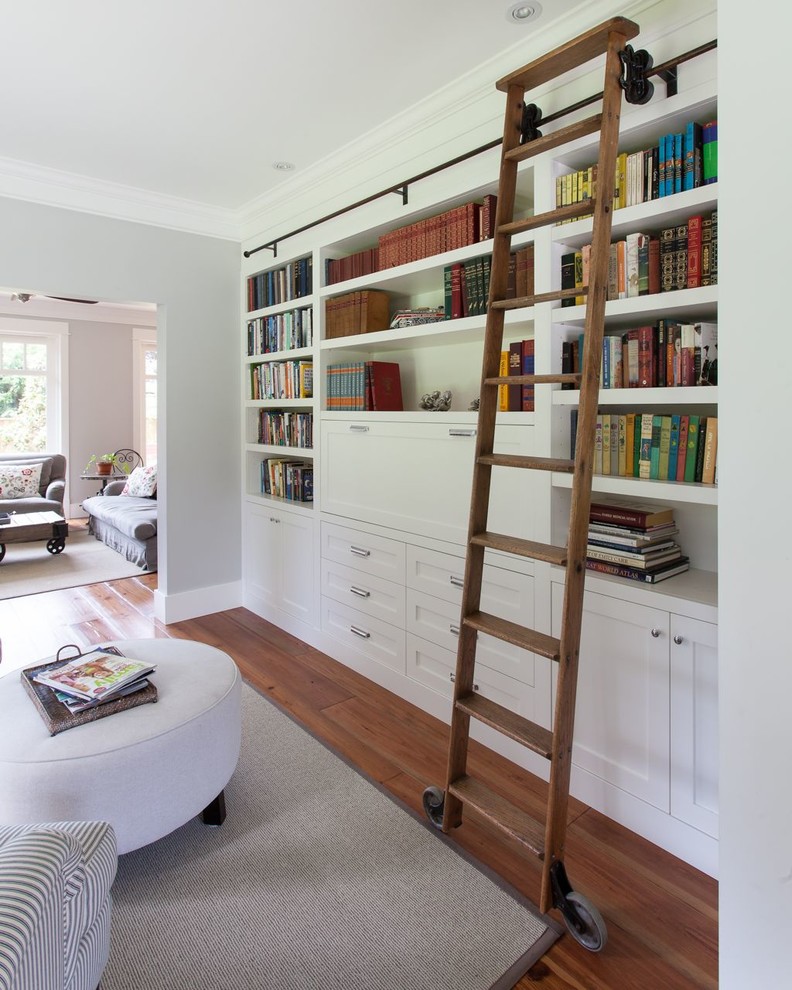 Diseño de sala de estar con biblioteca cerrada clásica con paredes grises y suelo de madera oscura