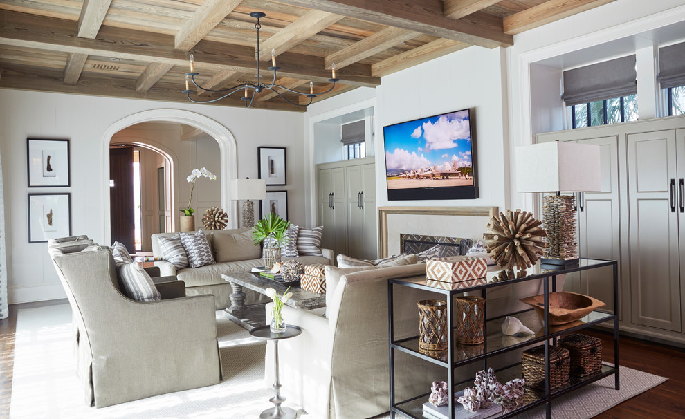На фото: гостиная комната в морском стиле с белыми стенами, паркетным полом среднего тона, стандартным камином, телевизором на стене и коричневым полом с