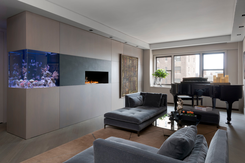 Mittelgroßes, Fernseherloses, Offenes Modernes Musikzimmer mit brauner Wandfarbe, Betonboden, Gaskamin, Kaminumrandung aus Metall und grauem Boden in New York