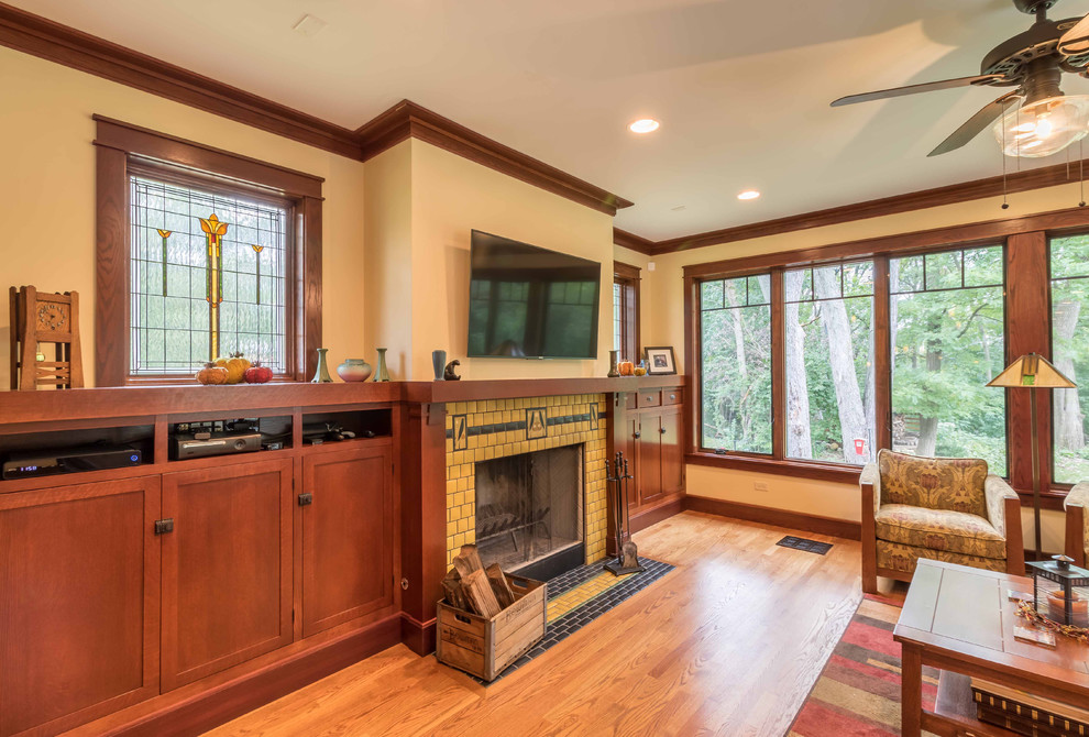 Medium sized classic open plan games room in Chicago with beige walls, light hardwood flooring, a standard fireplace, a tiled fireplace surround, a wall mounted tv, brown floors, a chimney breast, a wallpapered ceiling and wallpapered walls.
