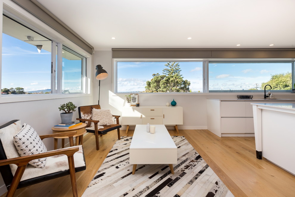 Ejemplo de sala de estar abierta contemporánea pequeña con paredes blancas y suelo de madera clara
