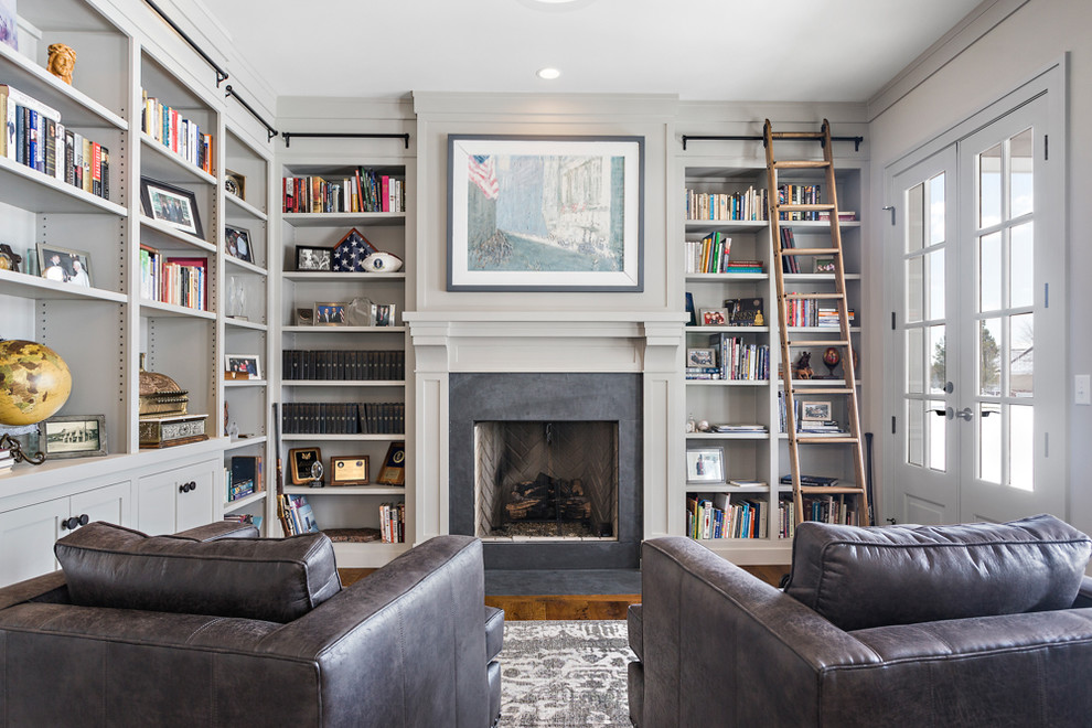 Diseño de sala de estar con biblioteca cerrada tradicional sin televisor con paredes grises, suelo de madera oscura, todas las chimeneas y alfombra