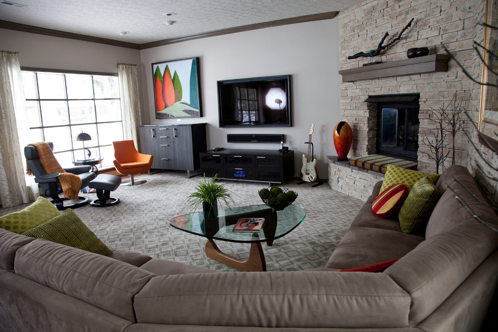 Ejemplo de sala de estar abierta tradicional renovada grande con moqueta, todas las chimeneas, marco de chimenea de piedra, paredes grises y televisor colgado en la pared