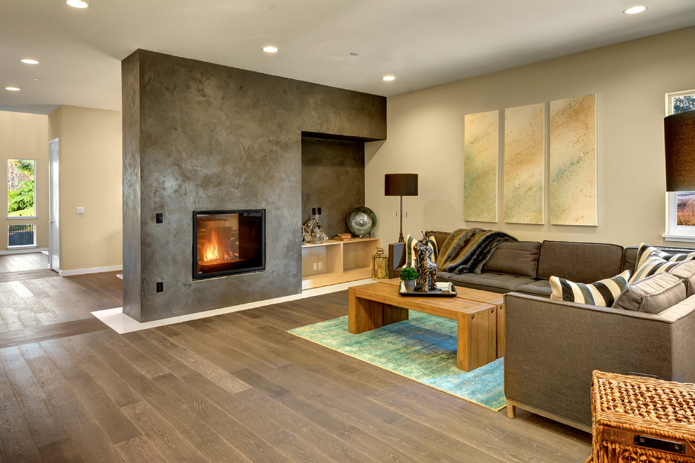 Minimalist open concept light wood floor family room photo in Seattle with gray walls, a two-sided fireplace, a concrete fireplace and no tv