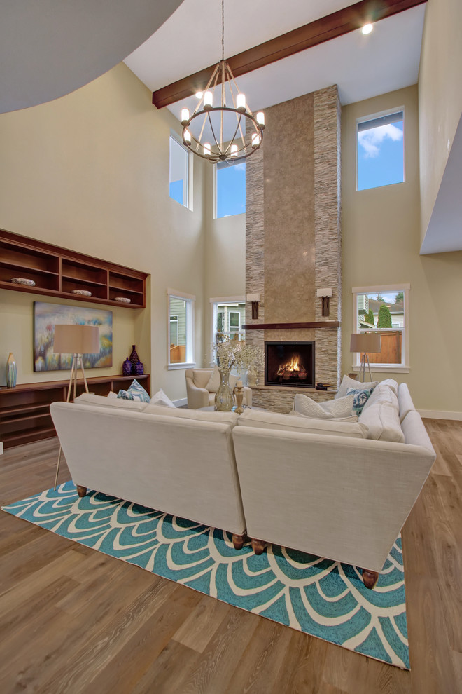 This is an example of a traditional open plan games room in Seattle with medium hardwood flooring, a standard fireplace and a stone fireplace surround.
